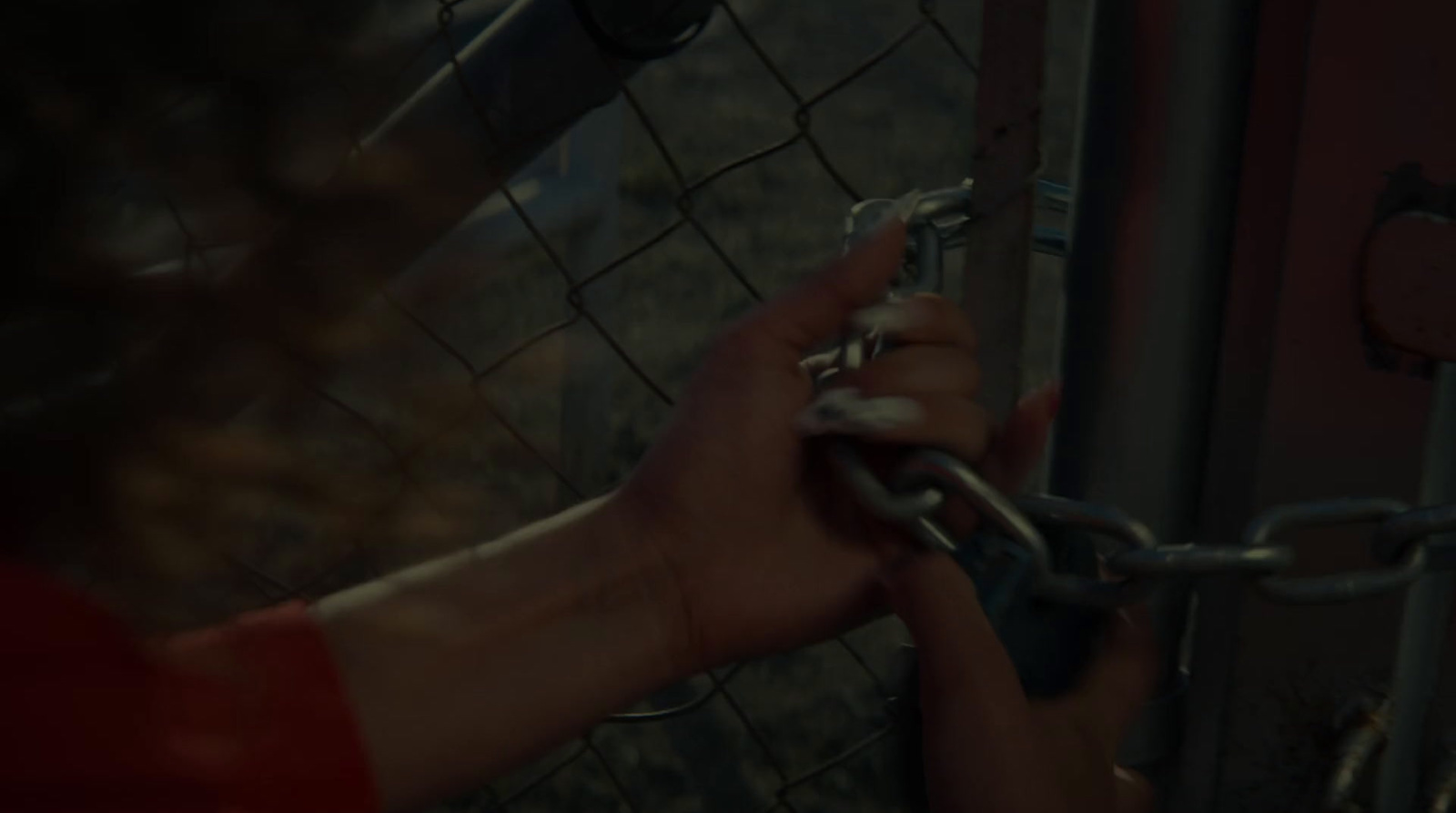 a person is holding a chain on a fence