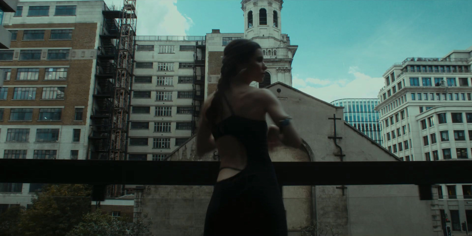 a woman in a black dress standing in front of a building