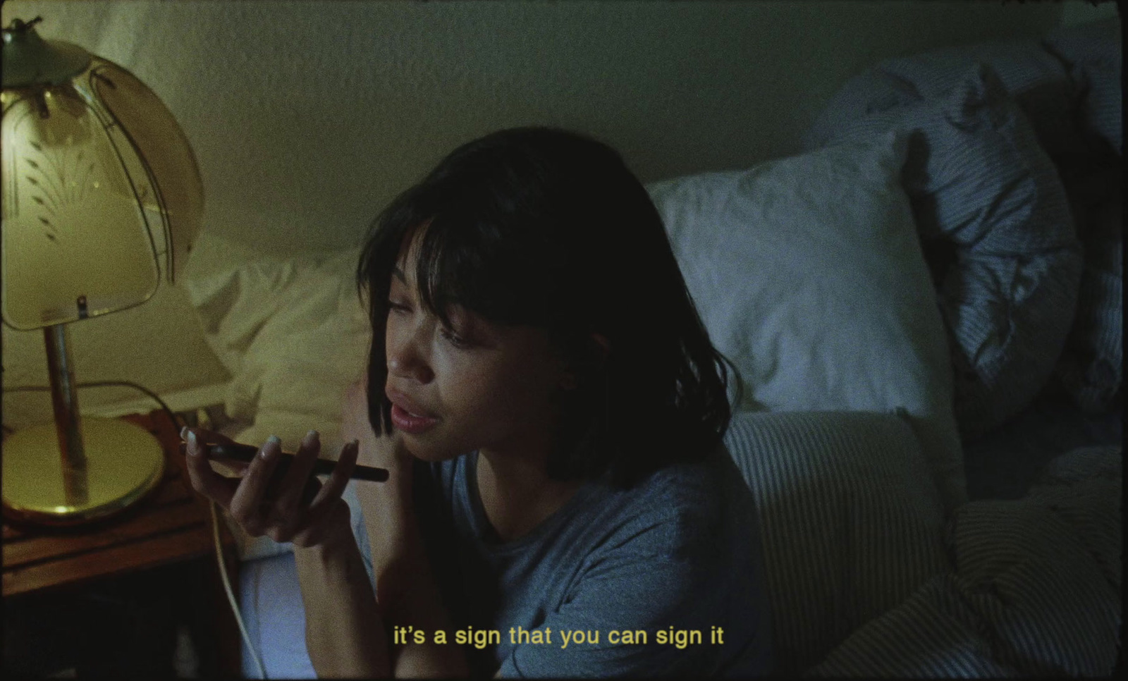 a woman laying in bed smoking a cigarette