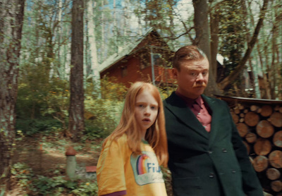 a man standing next to a little girl in a forest