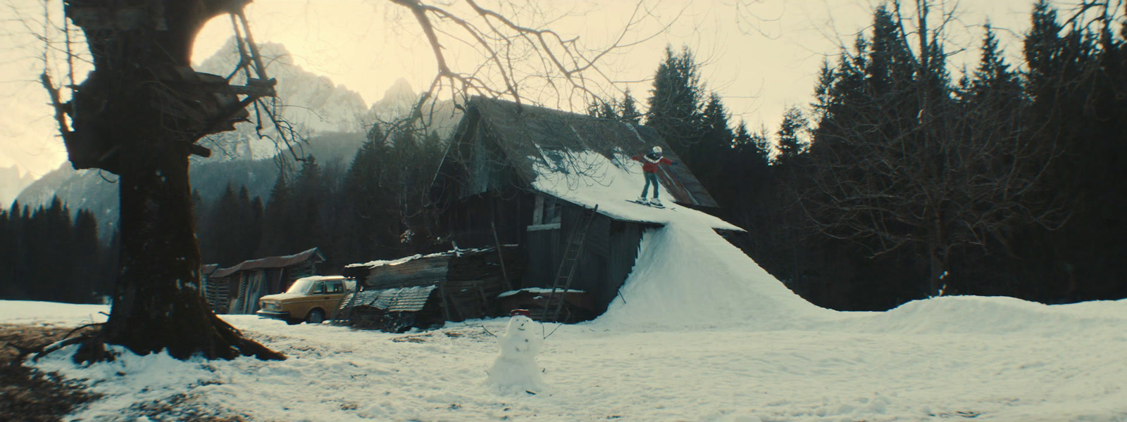 a truck is parked in the snow next to a house