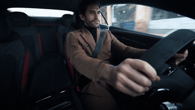 a man sitting in a car holding a steering wheel