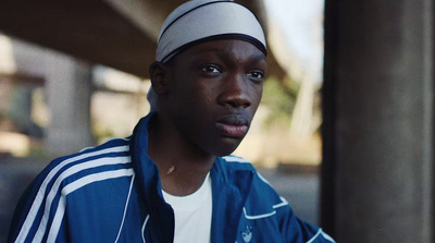 a man in a blue jacket and a white hat