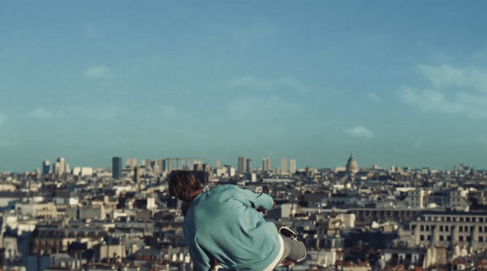 a man sitting on a ledge looking at the city