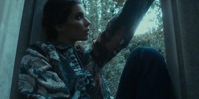 a woman sitting on a window sill next to a tree