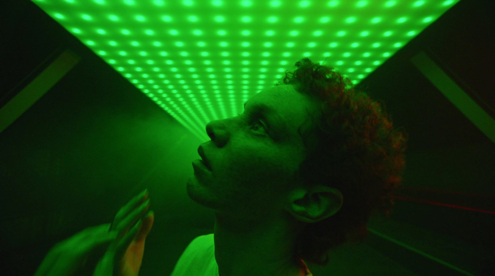 a man standing in front of a green light