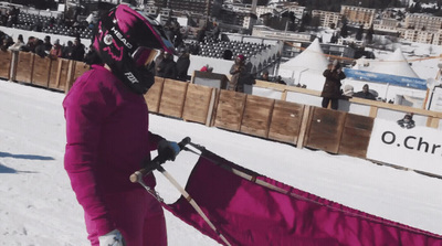 a person in a purple snow suit holding a snowboard