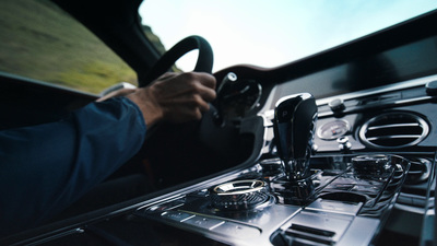 a man driving a car with a steering wheel