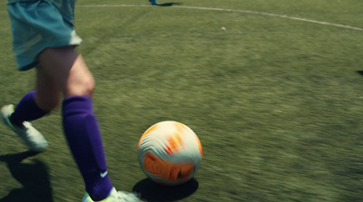 a person kicking a soccer ball on a field