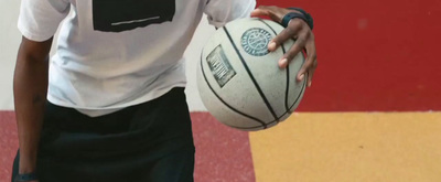 a young man holding a basketball on a court