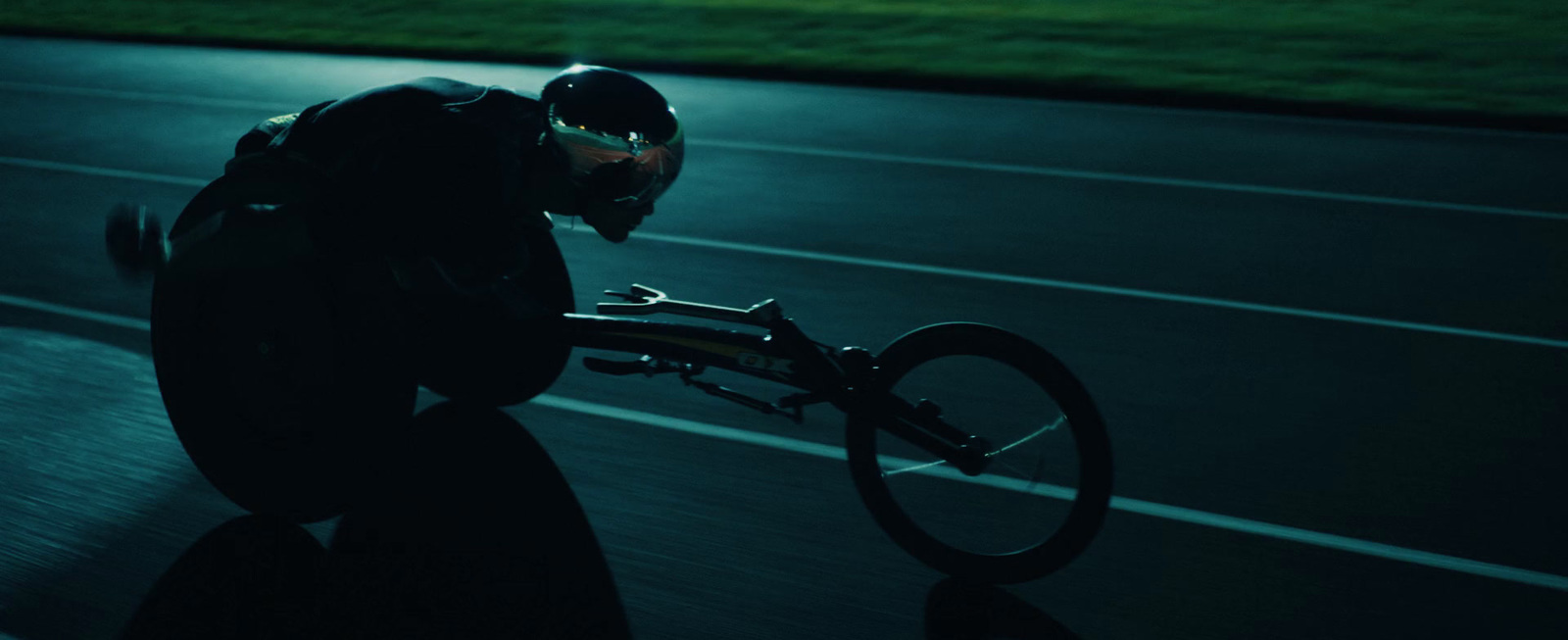 a man riding a bike down a road at night