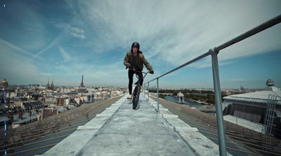 a man riding a bike down a metal hand rail