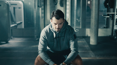 a man squatting on a bench in a gym