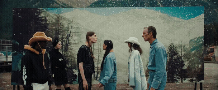 a group of people standing in front of a painting