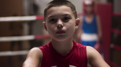 a young boy standing in a boxing ring