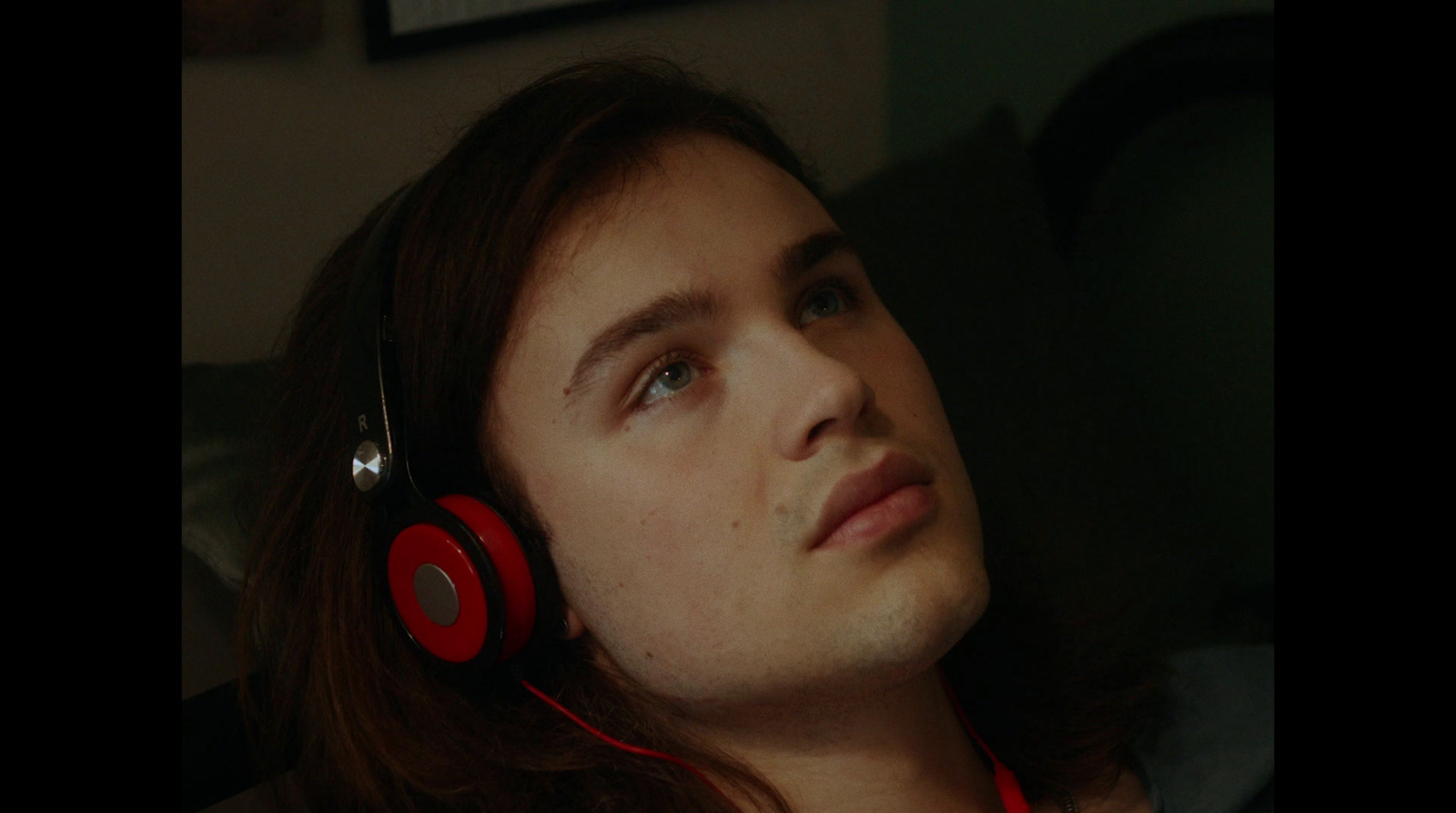 a man with long hair wearing red headphones