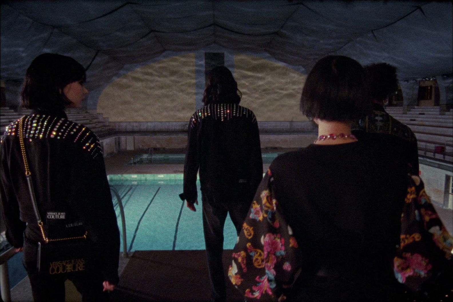 a group of women standing next to each other near a pool