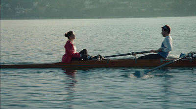 a man and a woman sitting on a boat in the water