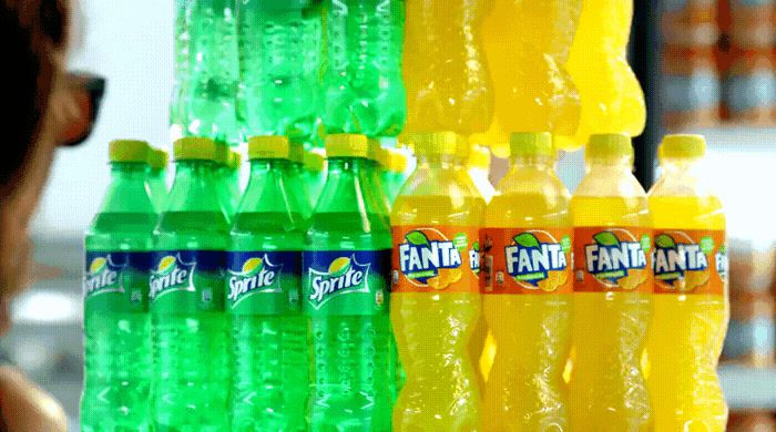 a woman looking at a display of fannie soda bottles