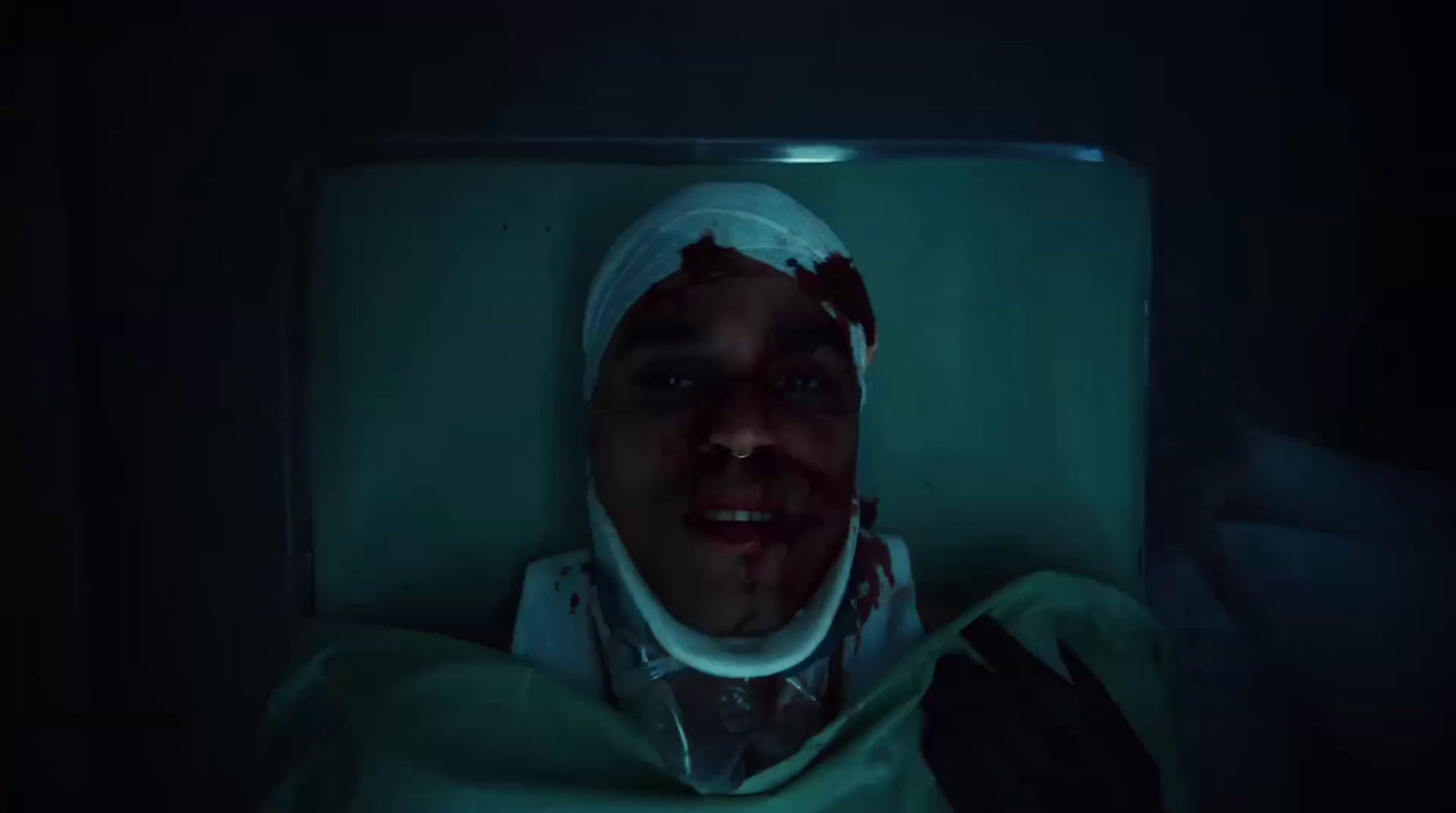 a man in a hospital bed with a bandage on his head