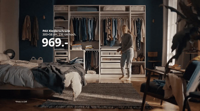 a woman standing in a bedroom next to a bed