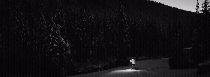 a man riding a snowboard down a snow covered slope