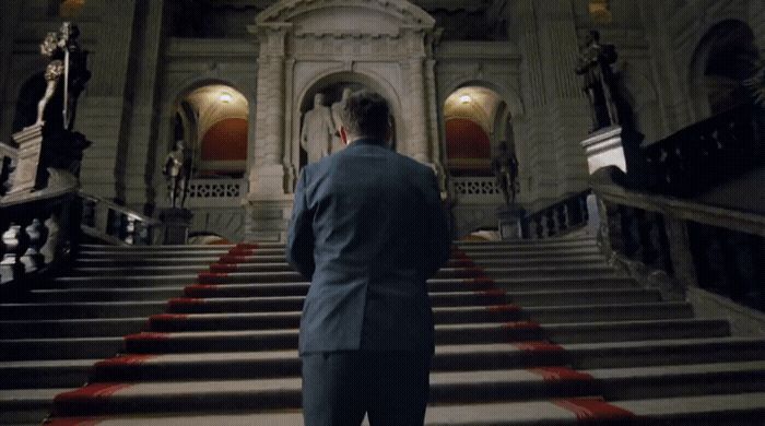 a man in a suit standing on a set of stairs