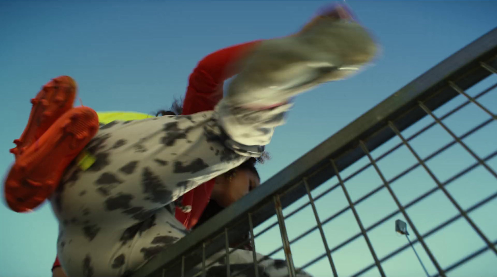 a man riding a skateboard down the side of a metal fence