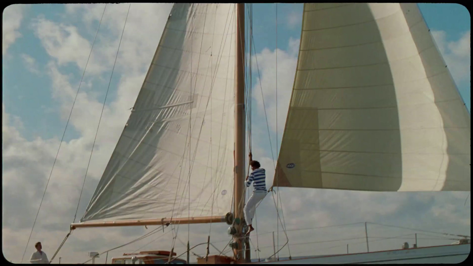 a man standing on the side of a sailboat