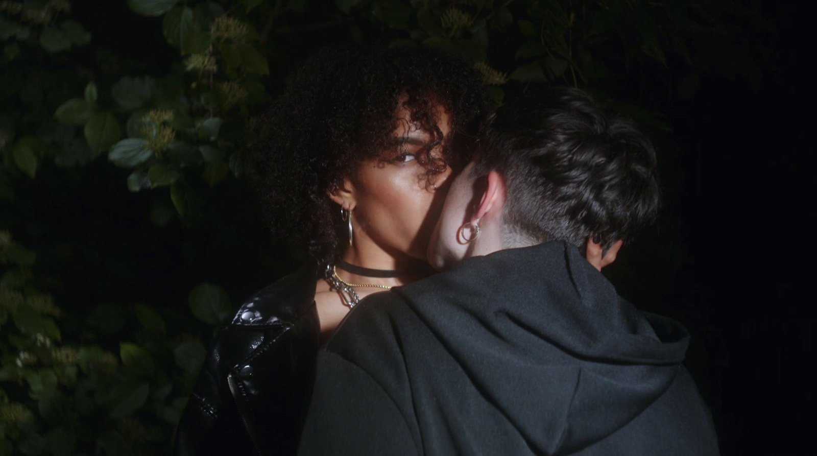 a man and a woman kissing in the dark