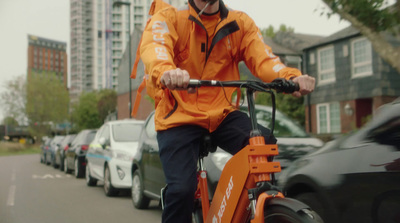 a man riding a bike down a street next to parked cars