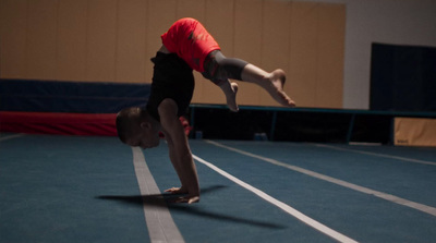 a young man is doing a handstand on a skateboard