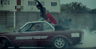 a man riding on the back of a red car