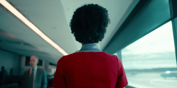 a woman in a red jacket looking out a window