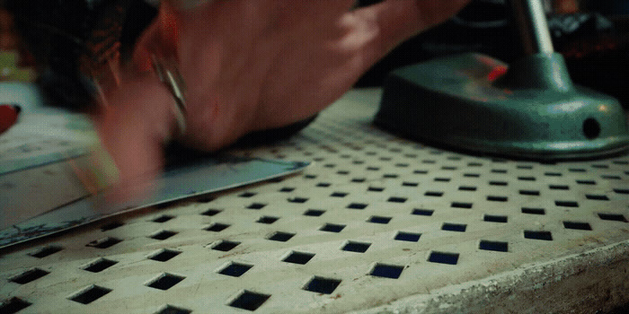 a close up of a person working on a tile