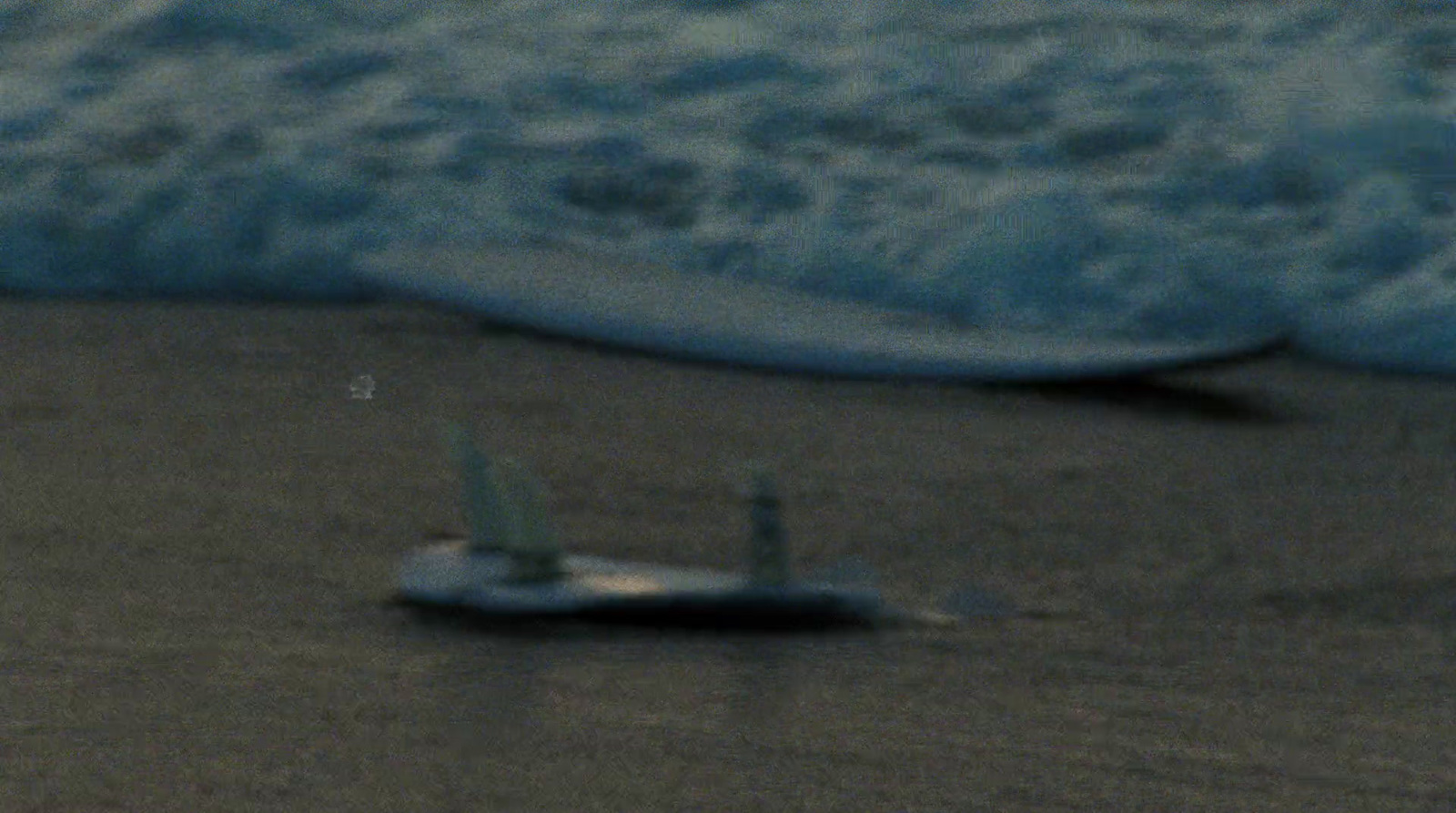 a small toy airplane sitting on top of a sandy beach