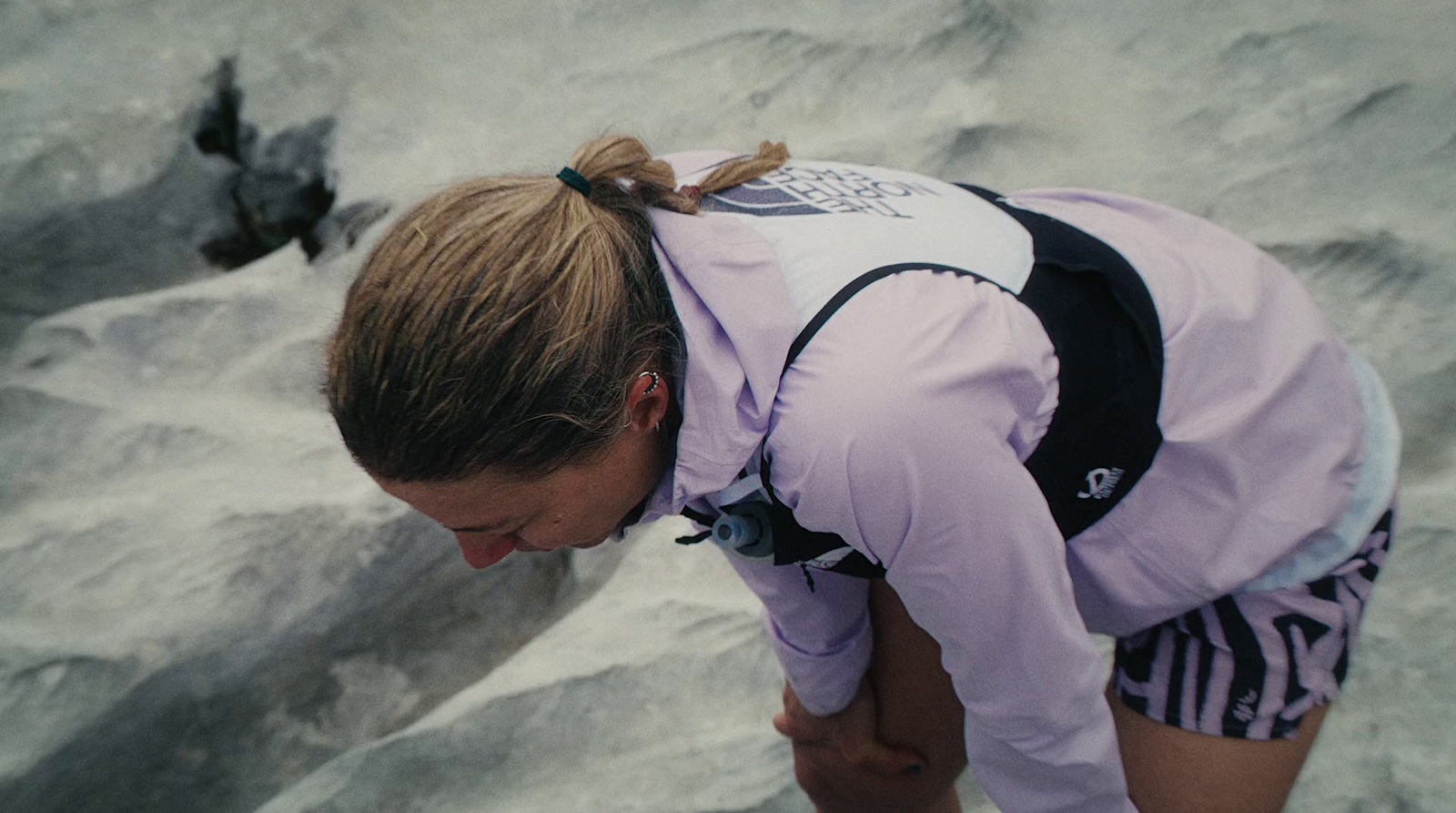 a woman with a backpack looking down at something