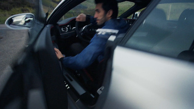 a man sitting in a car driving down a road