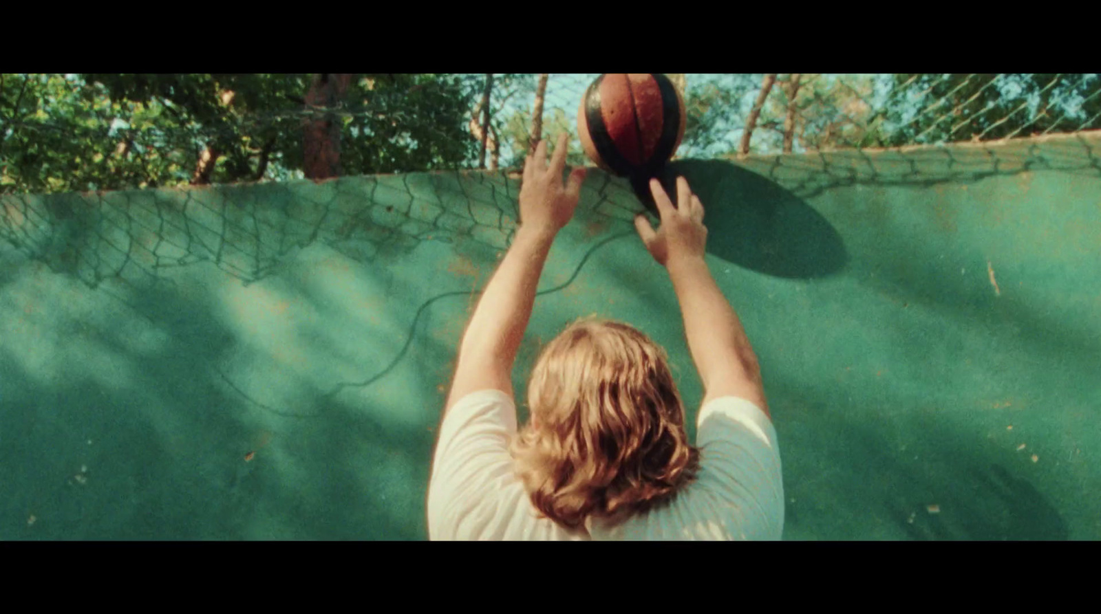 a person reaching up to catch a basketball