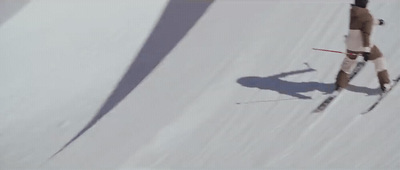 a man riding skis down a snow covered slope