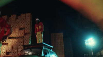 two men standing on top of a truck at night