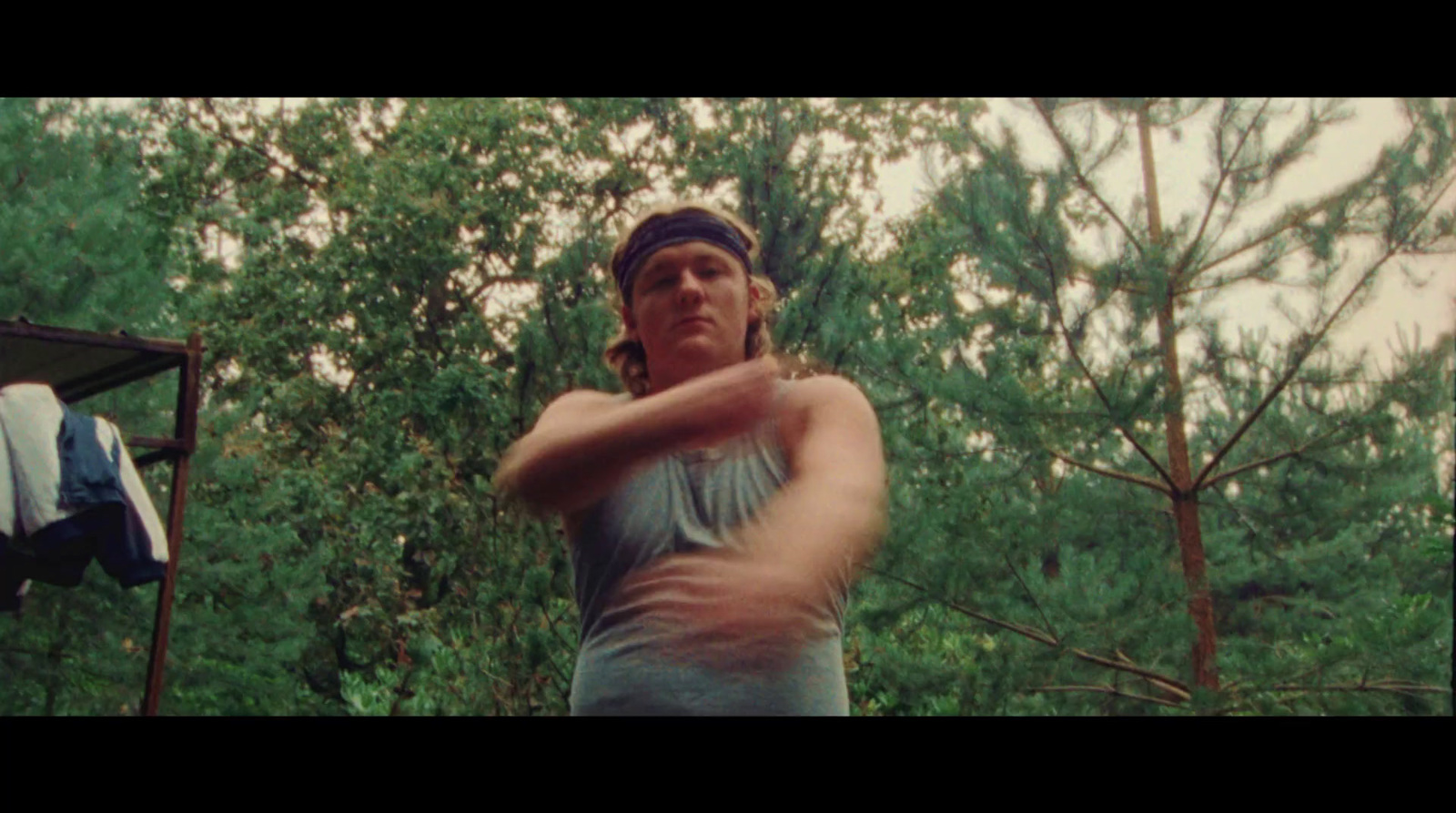 a man swinging a baseball bat in a wooded area