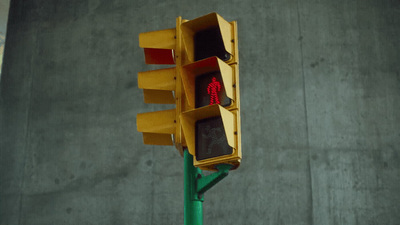 a traffic light on a green pole with a red light