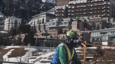 a man riding a snowboard down a snow covered slope