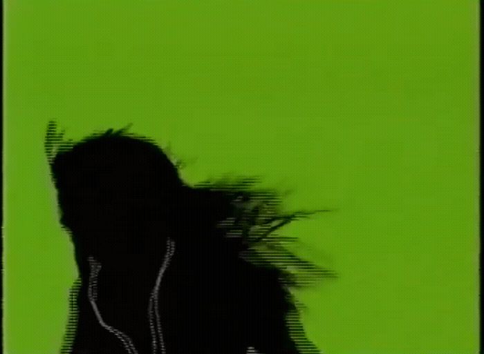 a person with headphones in front of a green background