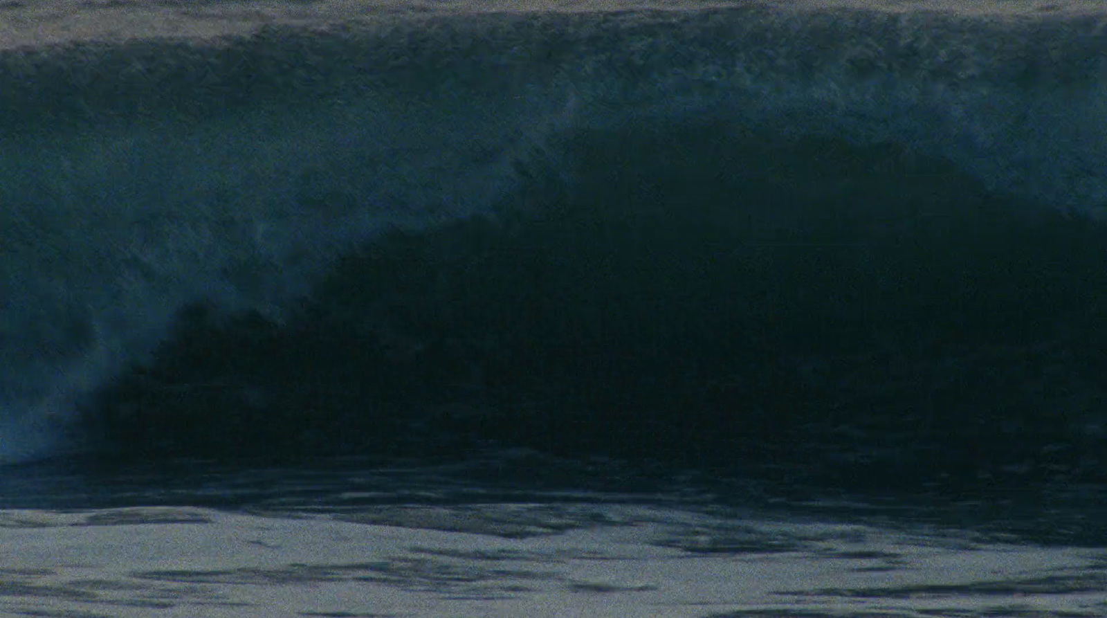 a man riding a wave on top of a surfboard