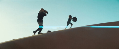 a group of people standing on top of a sand dune