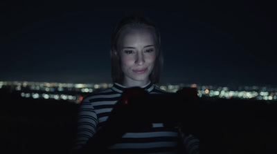 a woman in striped shirt holding a cell phone