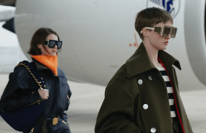 a man and a woman walking next to an airplane