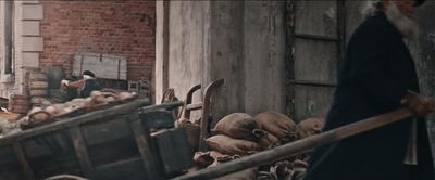 a man pushing a wheelbarrow full of wood